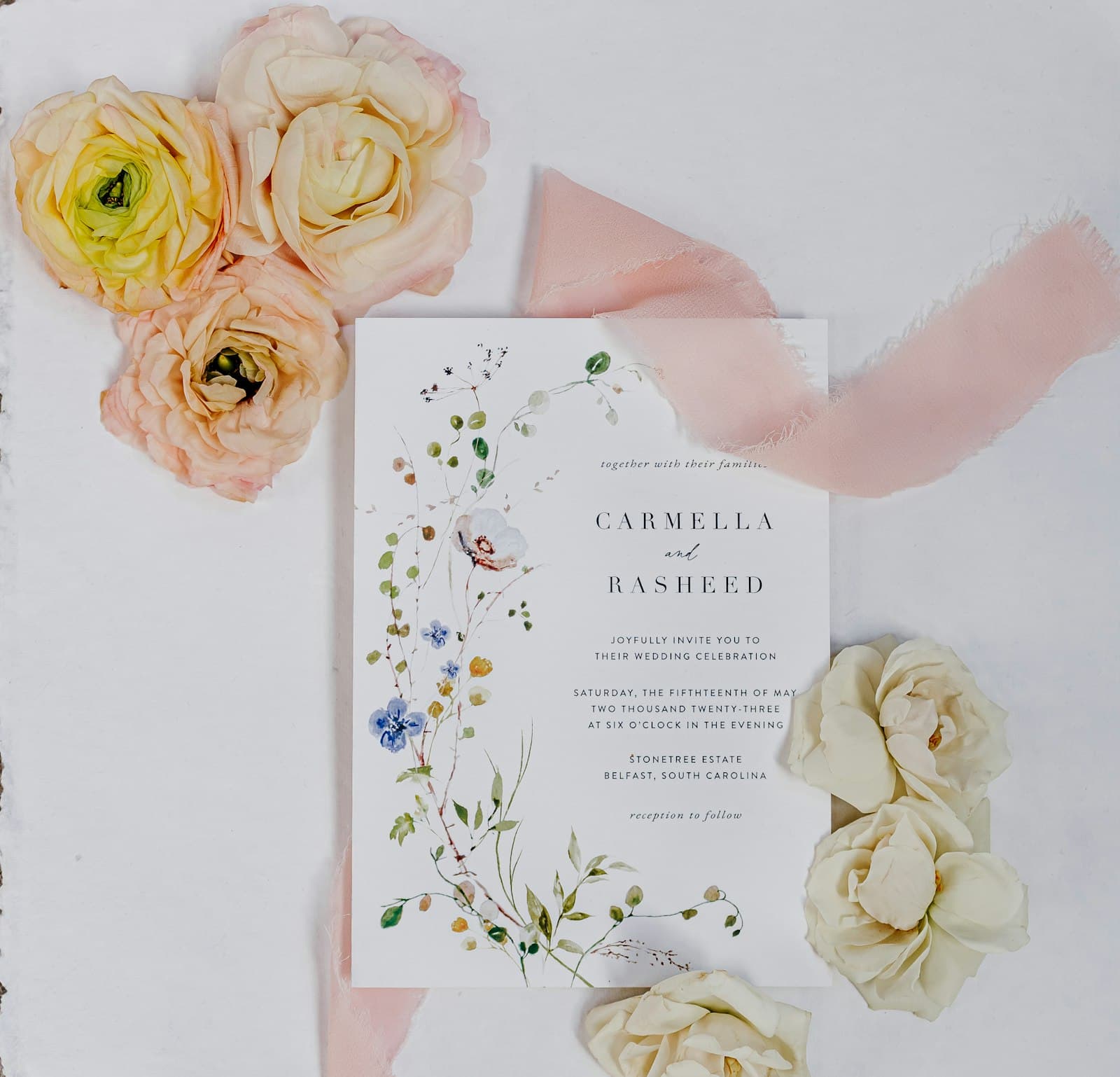 Wedding invitation suite styled with ribbon and floral details